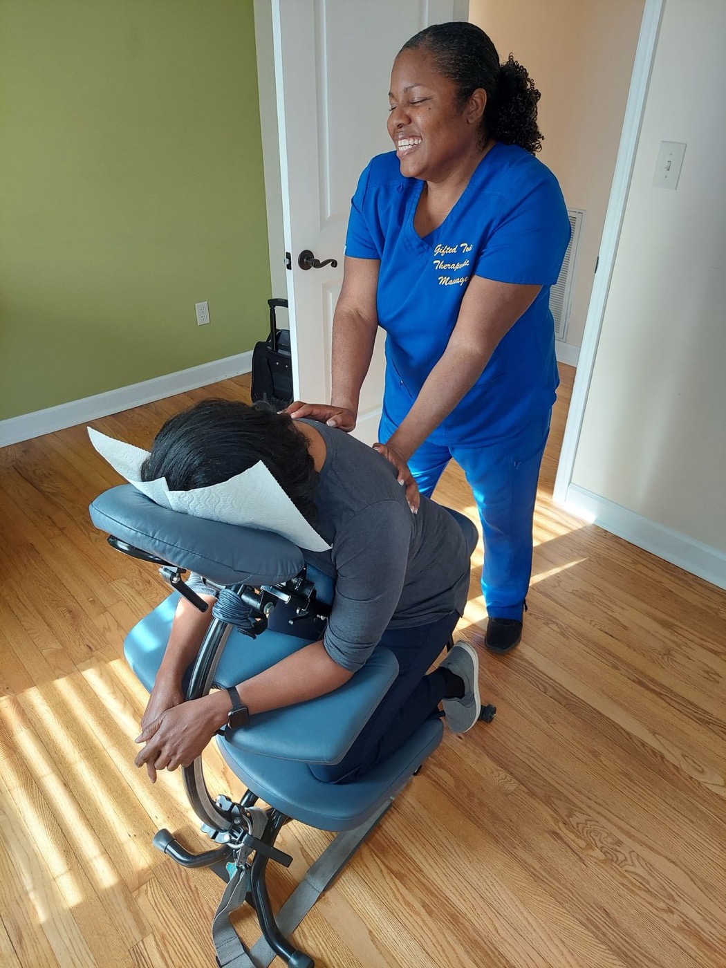 Etete giving a chair massage in a bright room